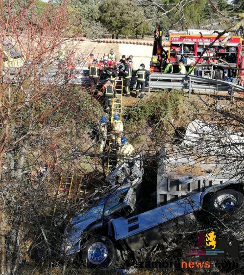 Los bomberos socorren y sacan de un cami&oacute;n a su conductor herido que ha sido evacuado en helic&oacute;ptero tras el vuelco en una cunet